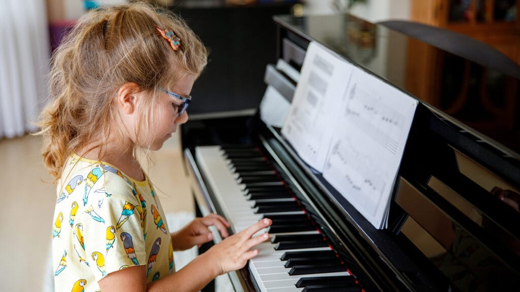 Little girl learning to play the piano