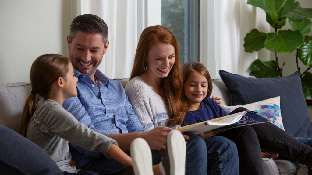 Family sitting on couch reading Christofferson moving resources