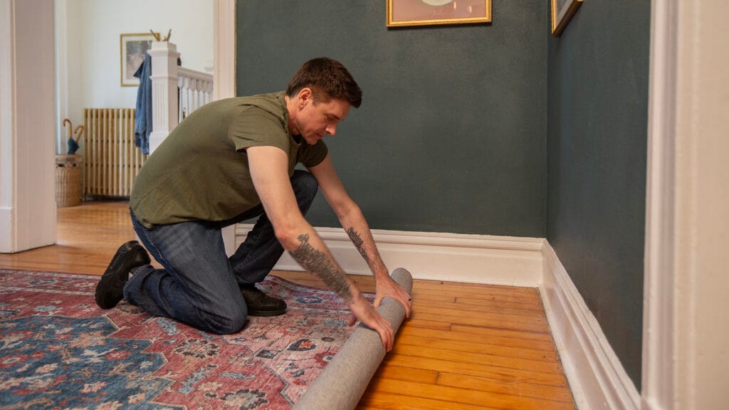 Home-owner rolling up bedroom rug