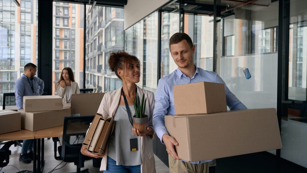 Young company workers packing for office move