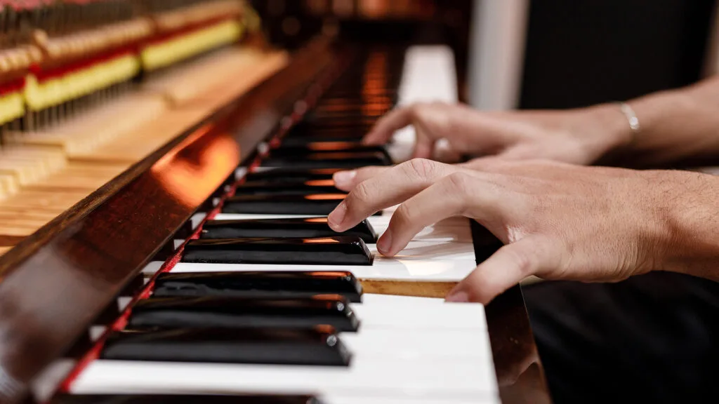 Close up of an open piano with pianist playing