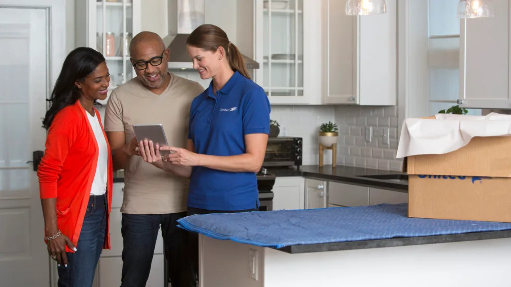 Residential moving service, with home-owners and United Van Lines employee reviewing documents