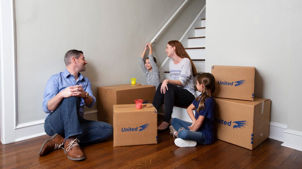 Family ready to move with moving boxes surrounding them