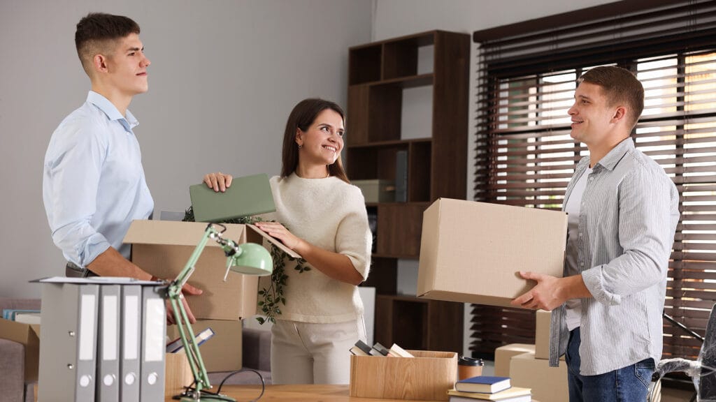 Group of employees packing belongings into boxes
