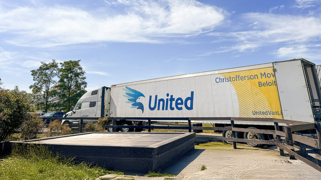Wide shot of Christofferson Moving & Storage semi-truck in a residential area, being loaded